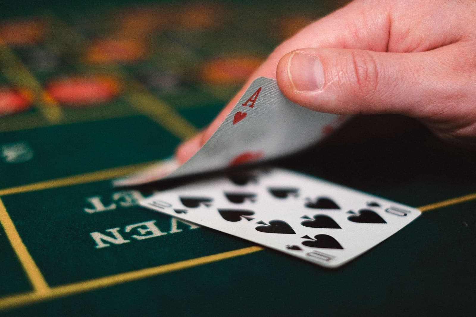 Blackjack table with playing cards and stacks of casino chips on green felt
