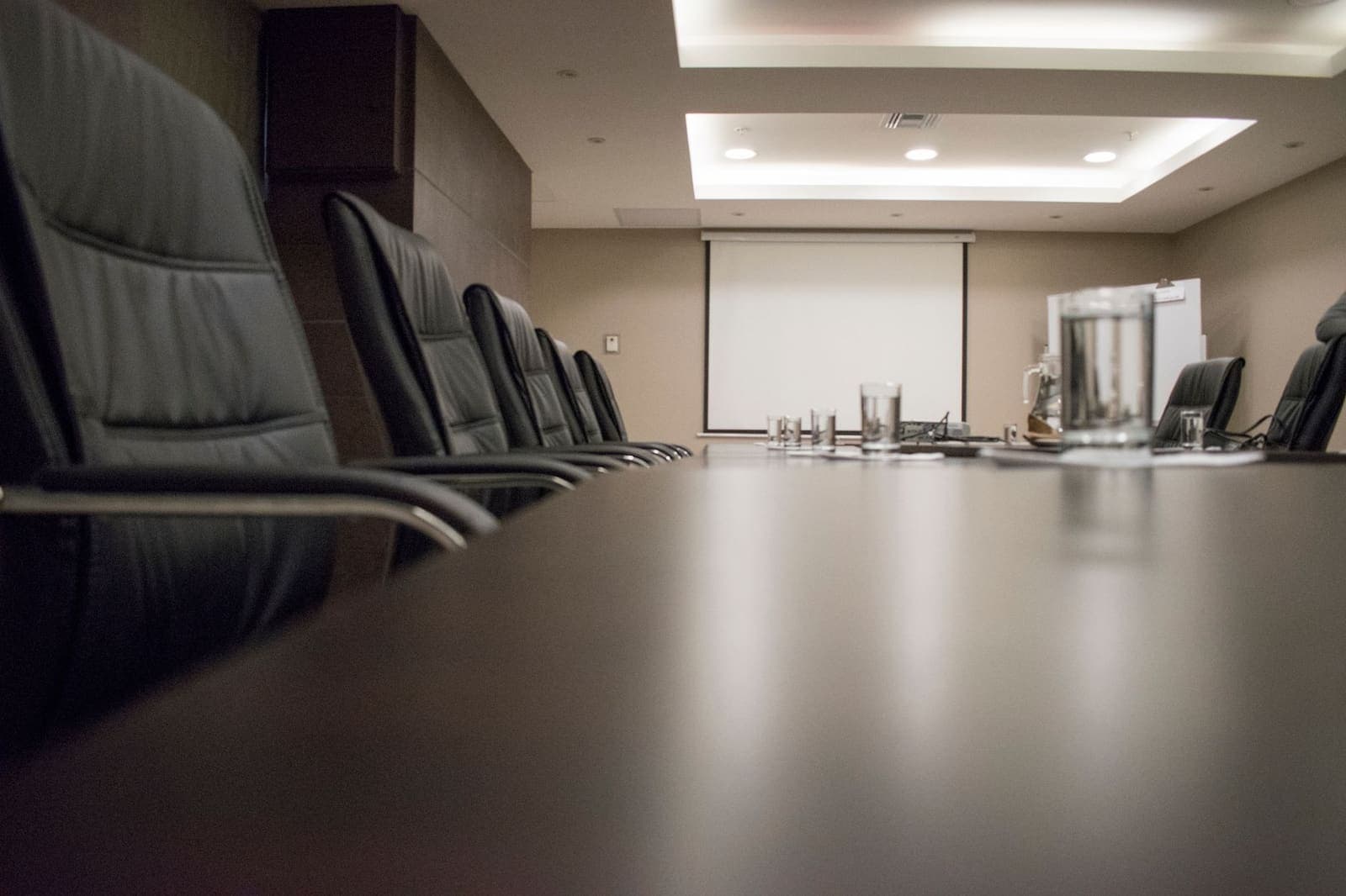 Empty boardroom table and chairs representing a corporate leadership appointment