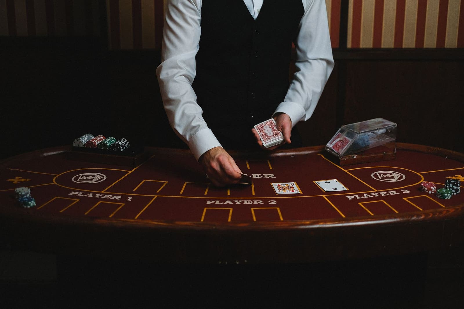 Blackjack table with playing cards and casino chips under warm overhead lighting
